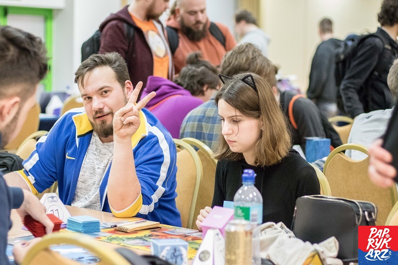 Photo of TCG players with one person showing peace sign by paprykarz
