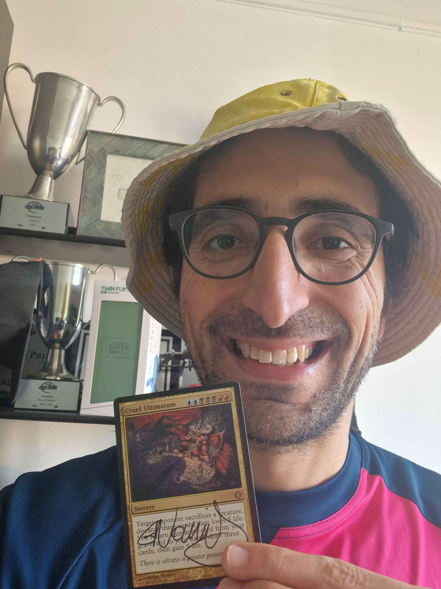 Gabriel Nassif holding signed Cruel Ultimatum Card from Magic: The Gathering
