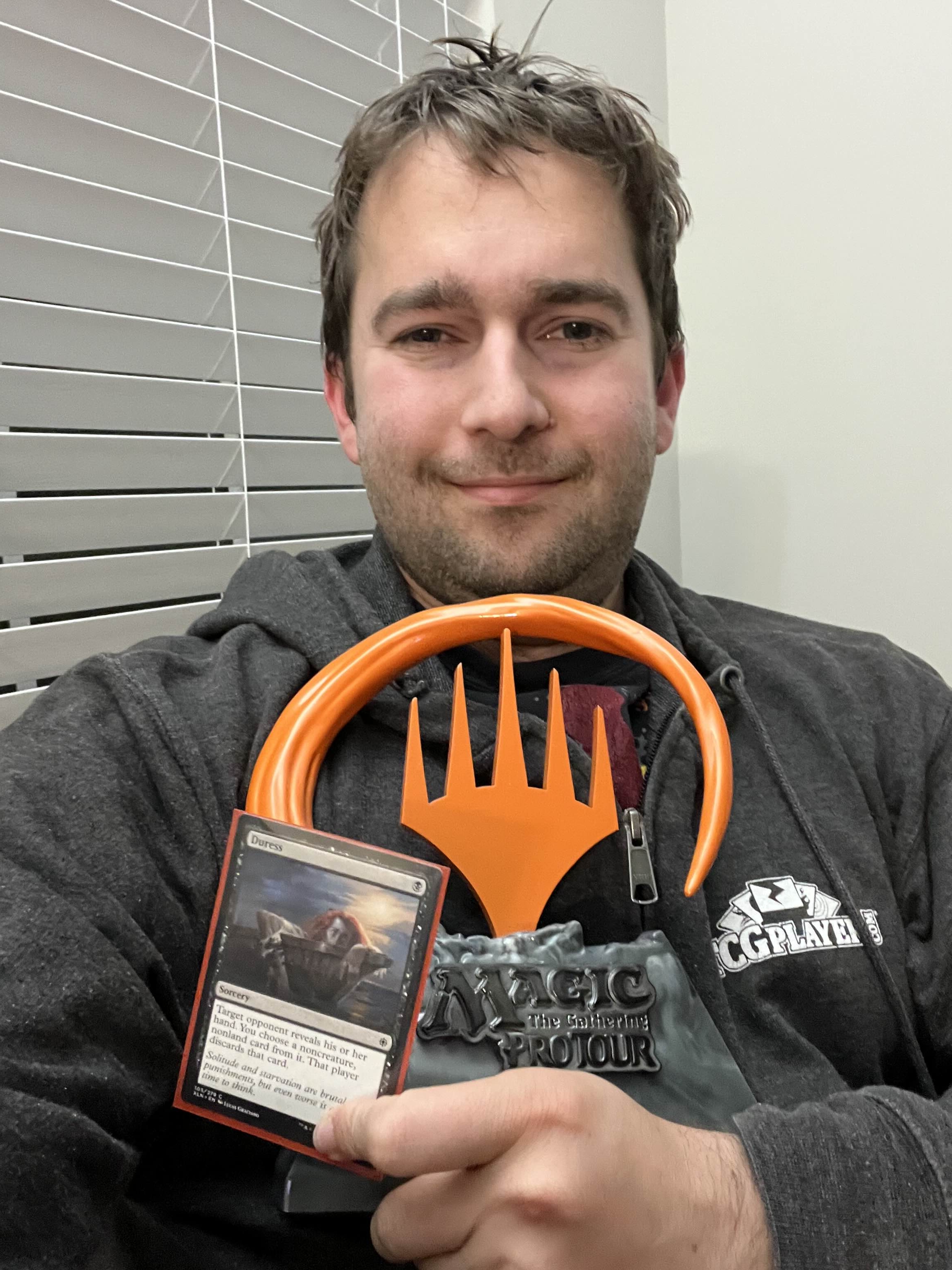Seth Manfield holding signed Duress Card from Magic: The Gathering