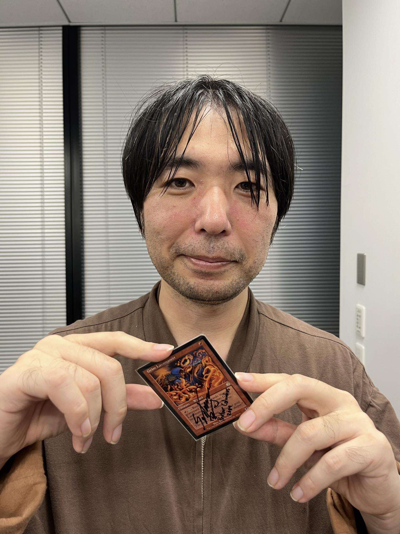 Shuhei Nakamura holding signed Grim Lavamancer card from Magic: The Gathering