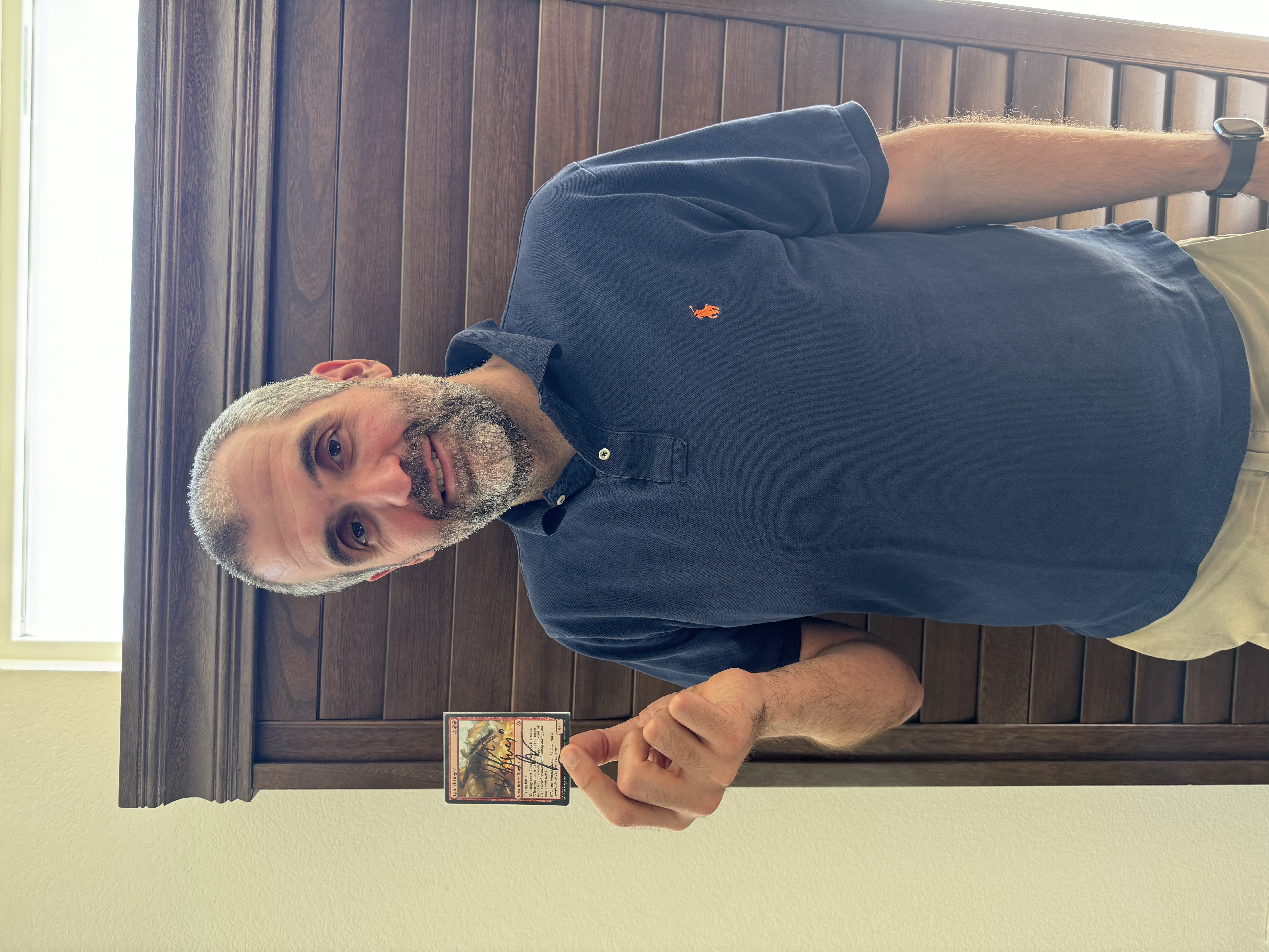 William Jensen holding signed Glorybringer Card from Magic: The Gathering