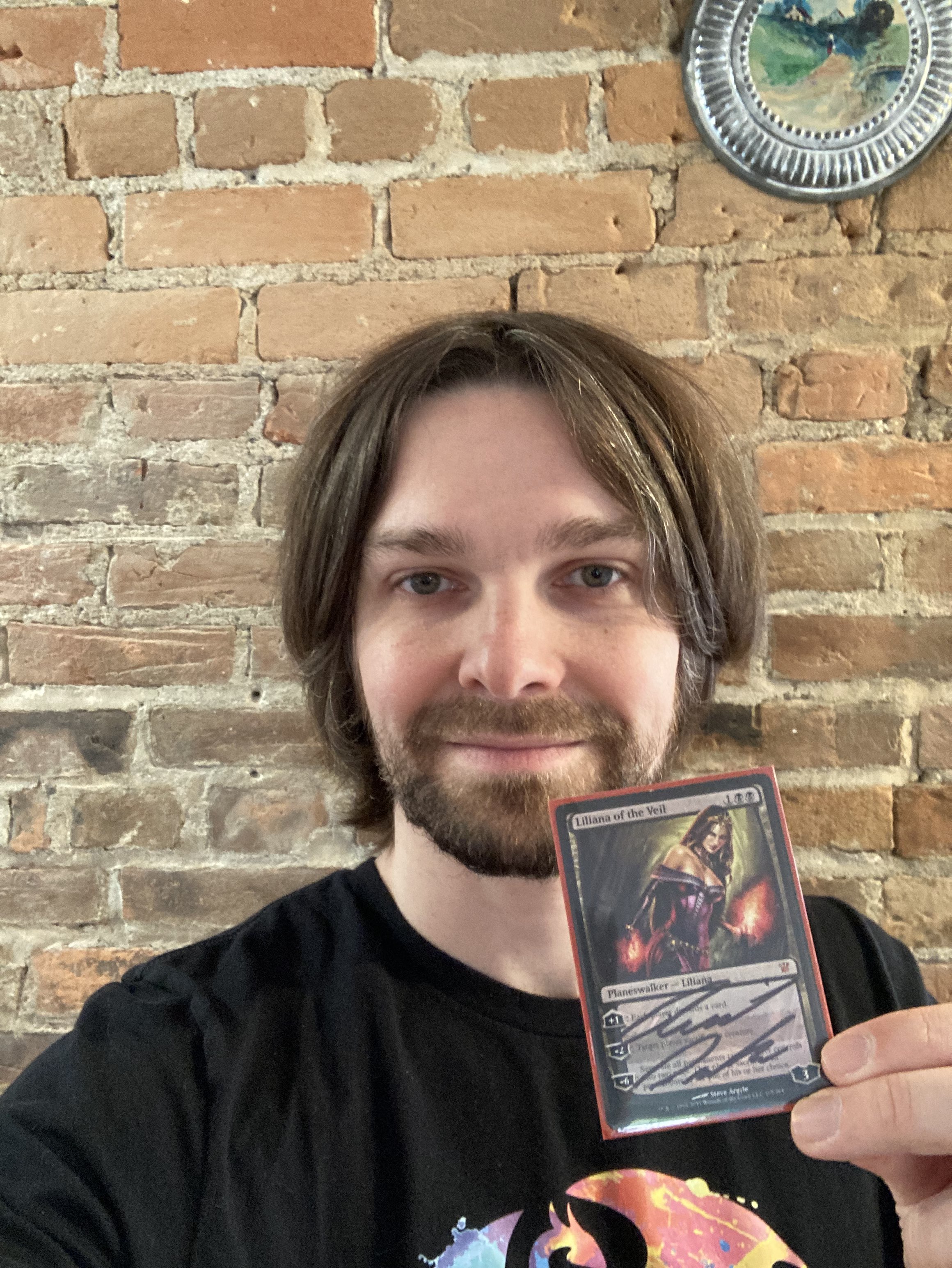 Reid Duke holding signed Liliana of the Veil Card from Magic: The Gathering
